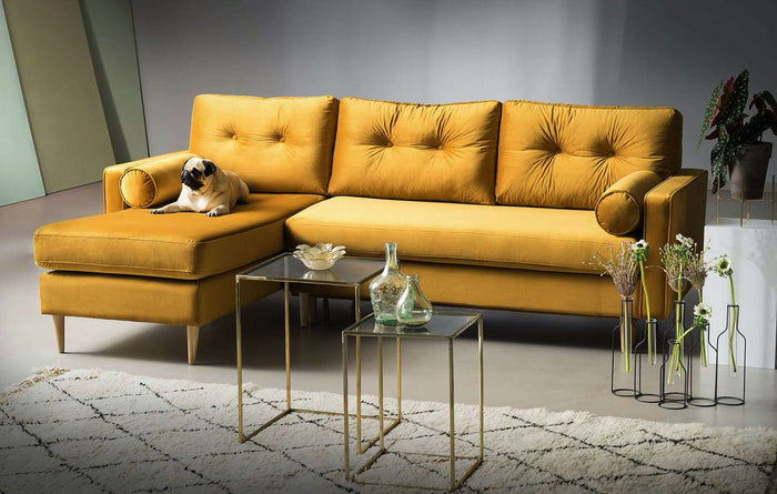 Garstyčių spalvos kampinė sofa-lova su stikliniais staliukais svetainėje